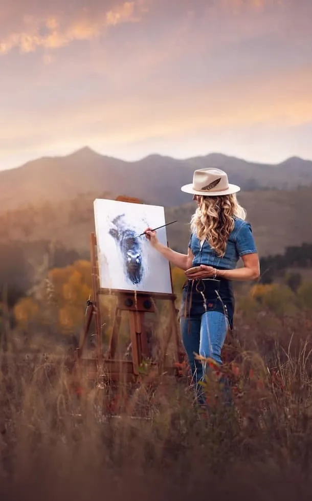 Shayna Larsen painting at an easel in the Colorado foothills